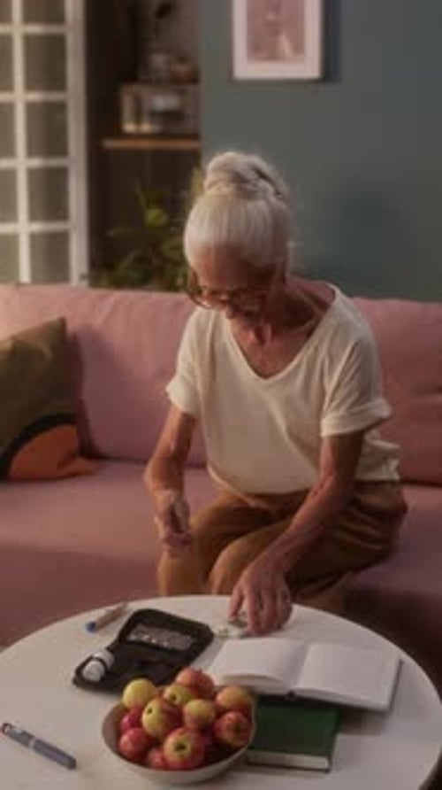 Senior Woman Checks Blood Sugar Level at Home