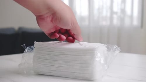 Hand Takes Disposable Face Mask From Stack
