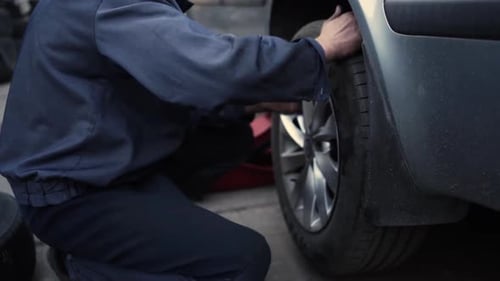 Car wheel service. Mechanic changing tires and rims, balancing the wheels