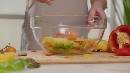 Fresh Vegetables Being Added to a Salad Bowl