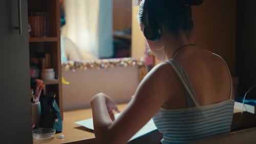 Adolescente étudiant avec des écouteurs au bureau, accent sur la musique lofi et concept de concentration,