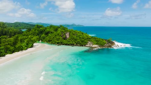 A Pristine Sandy Beach with Turquoise Waves and Dense Jungle Seychelles Mahe