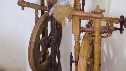 Slow parallax around antique spinning wheel in abandoned house.