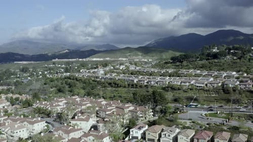 Absteigende Luftaufnahme einer Wohngegend in einem Vorort von Los Angeles, dunkle Wolken in der Ferne