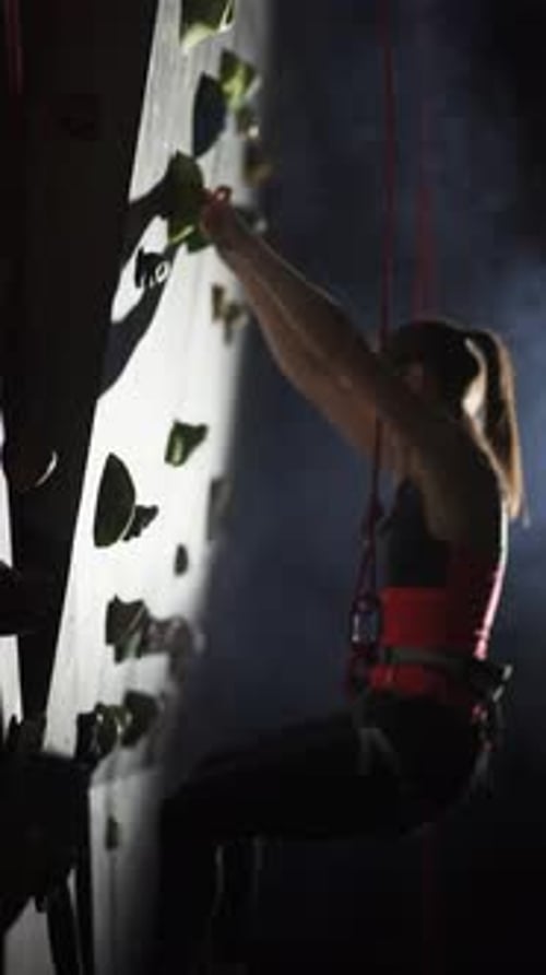 Woman Scaling Rock Climbing Wall Indoors