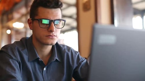 Young Adult Using Laptop Inside