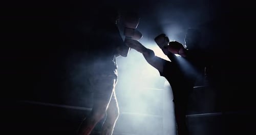 Un combattant de Muay Thai donne un coup de pied à son adversaire au ralenti à 800 images par seconde avec un effet Théâtral