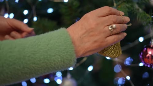 Decorating Christmas Tree with Golden Bell Ornament