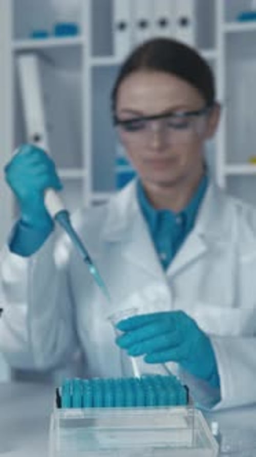 Woman Scientist Pipetting Blue Fluid in Laboratory