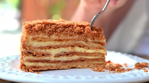 Woman eating a millefeuille cake, close up