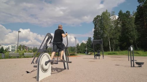 Man Working Out on Elliptical Machine in Park