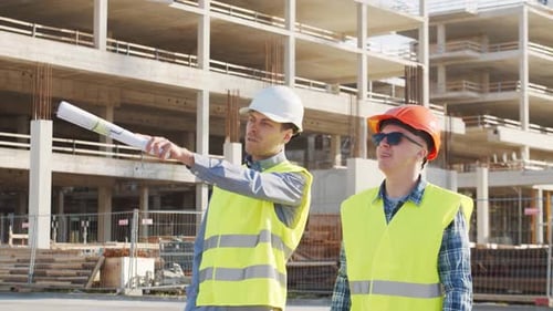 Professional Builders Standing in Front of Construction Site Office Building and Crane Background