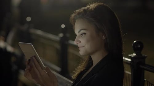 Young Woman Using Tablet Computer In The Park At Night
