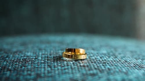 Elegant Gold Wedding Rings on Textured Blue Surface