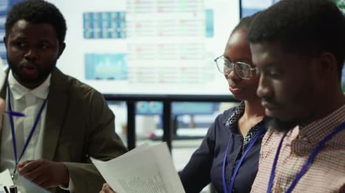 Team of Business Associates Reviewing Statistics and Infographics on a Tablet
