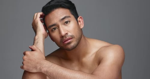 Face, cosmetics and Asian man with beauty, wellness and dermatology on a grey studio background