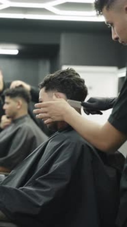 Barber Cuts Hair in Modern Urban Barbershop
