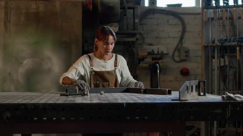 Frau macht Metallarbeiten in der Werkstatt