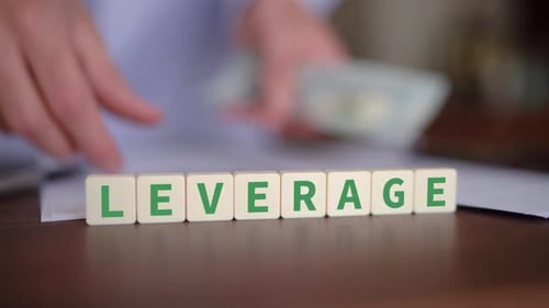 Concept of money leverage. Selective focus with person counting cash in the background.