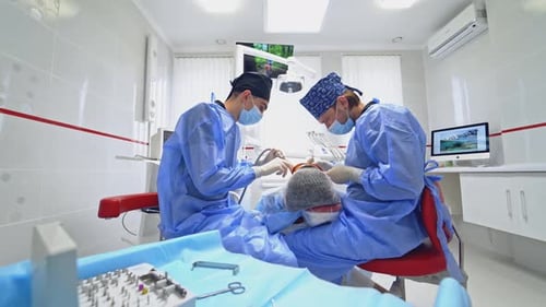 Dentist and assistant during teamwork. Patient getting dental treatment at dental office