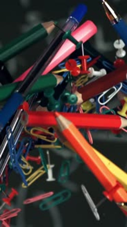 Different School Objects Fly and Fall Against the Background of the Blackboard Filmed on a Highspeed