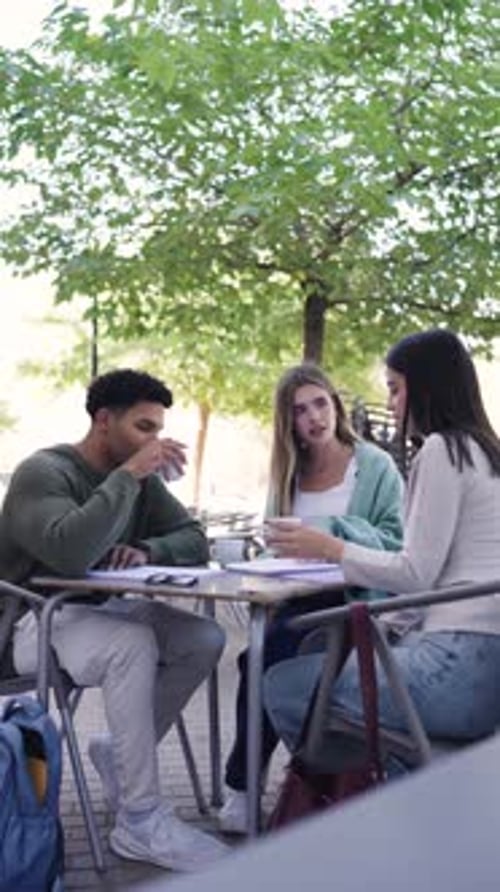 Group of University Students Collaborating at an Outdoor Campus Cafe