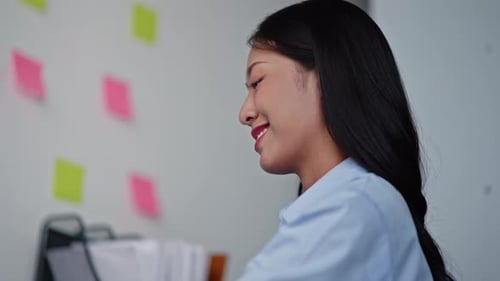 Smiling Woman Works on Laptop in Bright Office