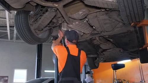 Un mecánico repara el chasis de un taller de automóviles