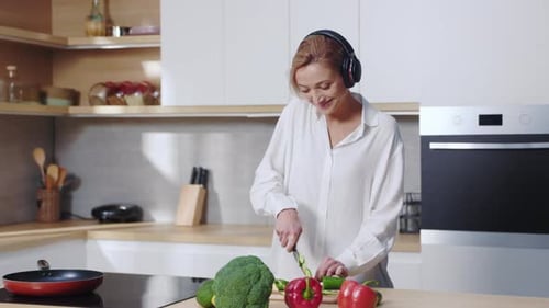 Woman Happily Prepares Healthy Vegetables in Kitchen