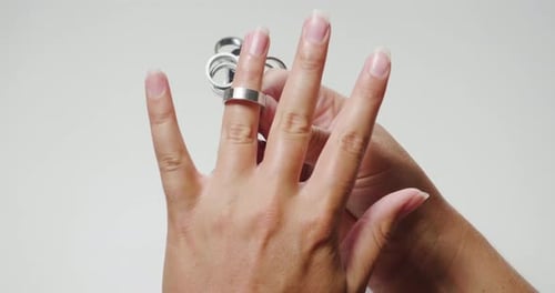 Close up of a girl's hand while she is trying a diamond ring. Concept: Silver, gold, fashion