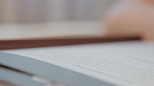 Examen minutieux d'un texte manuscrit avec une douce lumière du jour, scène calme d'un étudiant méticuleusement