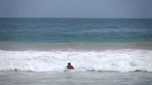 Surfer Paddling Out on Board in Ocean Waves