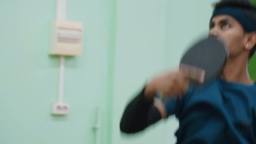 Gros plan d'un joueur de tennis professionnel s'entraînant en intérieur