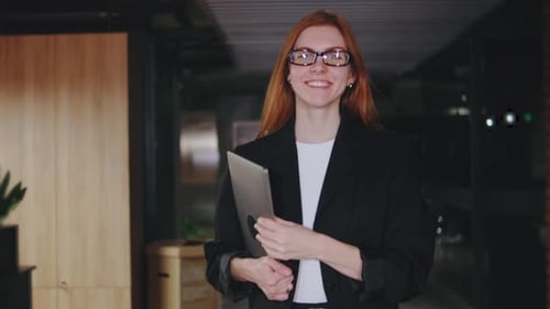 A Confident Businesswoman Smiles in Her Modern Office Showcasing Professionalism and a Positive