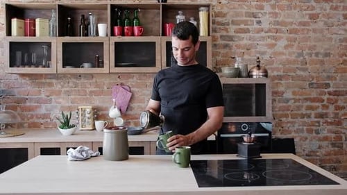 Young Attractive Man Making Coffee In The Kitchen For Breakfast