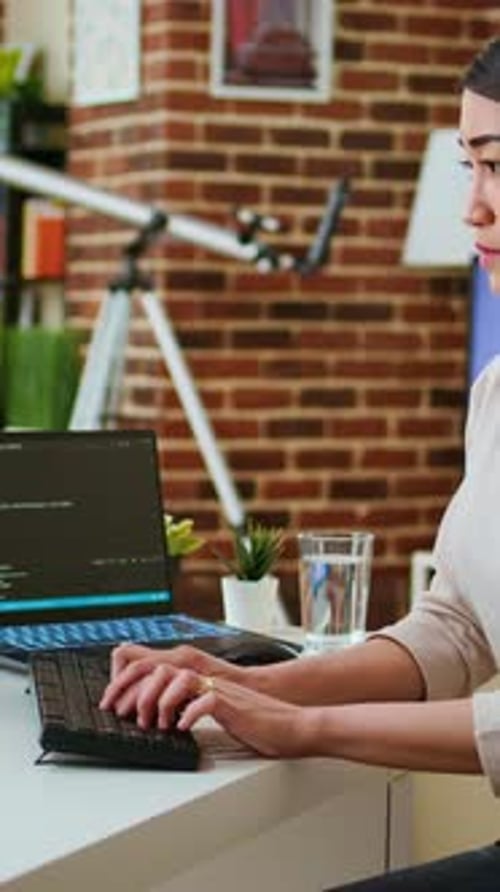 Vertical Video Professional Software Developer Types Code on a Laptop in a Sleek Workspace