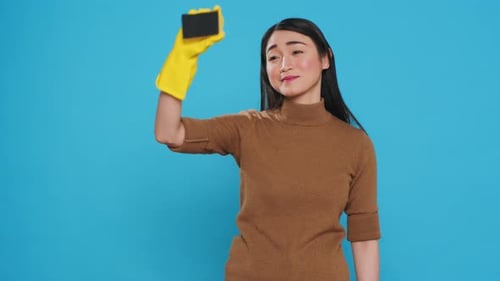 Woman Poses with Cleaning Sponge in Studio