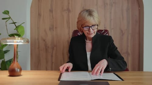 Senior Woman Reviewing Documents During Online Study
