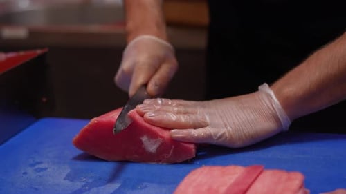 Crop Chef corta atún rojo en rodajas con un cuchillo