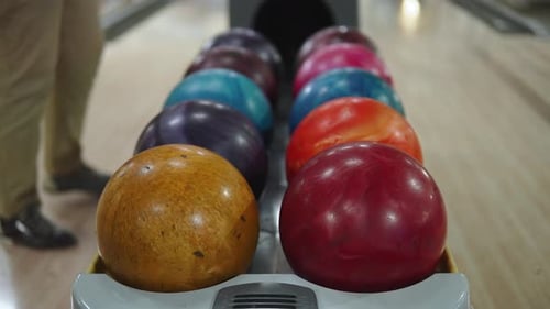 Mehrfarbige Bowlingkugeln liegen auf dem Rückstand der Bowlingbahn aus nächster Nähe