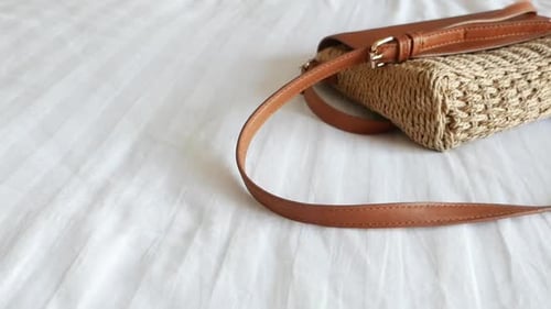 Sac tissé élégant avec sangle en cuir sur une surface blanche