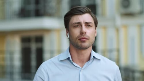 Portrait Serious Man Walking With Headphones At Street. Successful Businessman Talking By Wireles...