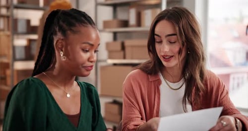 Two Young Women Discuss Business in Office