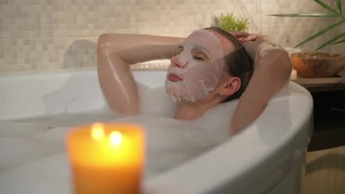 Woman Relaxing in a Bubble Bath with Mask