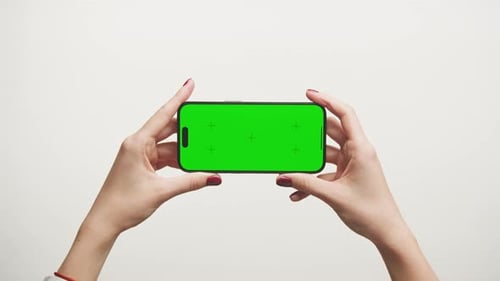 Hands Holding Smartphone with Green Screen on White Background