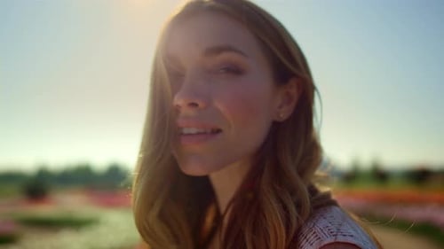 Smiling Woman in Field of Flowers bathed in Sunlight