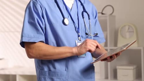 Medical worker using tablet in clinic, closeup