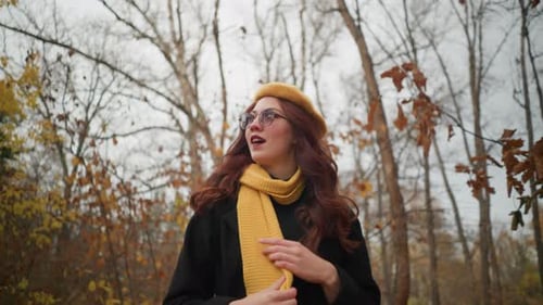 Elegant Woman in Yellow Beret Strolling Through Autumn Forest