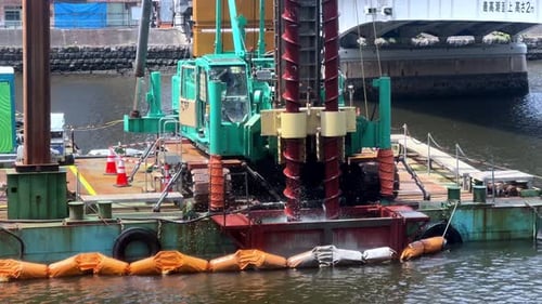 Large drilling working on a floating platform by the water