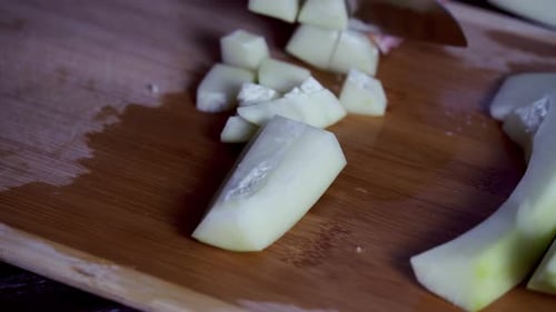 Papaya pieces being cut on cutting board to prep for a meal Green and ripe yellow organic fresh papa